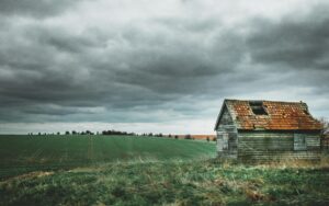 Damaged roof under stormy sky - v&v exteriors & remodeling co.